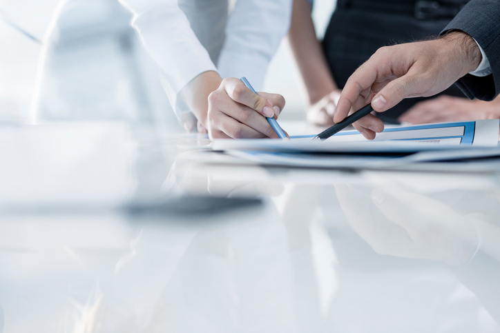 Explications about a document We see peoples'hands which explain things about a document