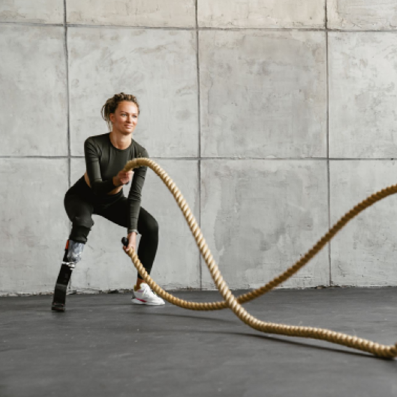 Junge Frau trainiert mit Ropes