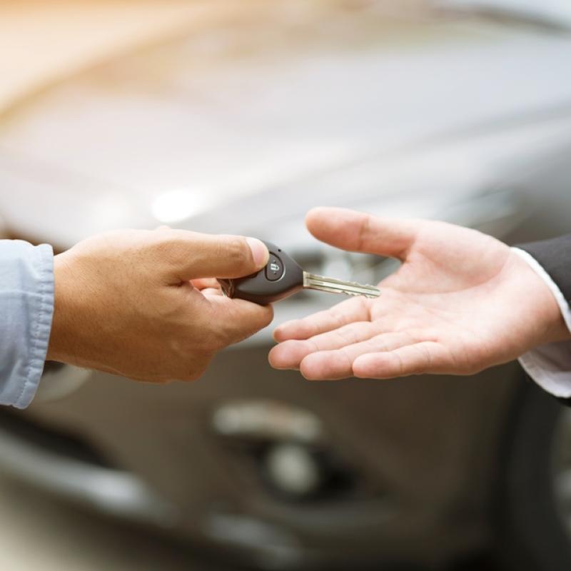 Schlüsselübergabe Auto im Hintergrund