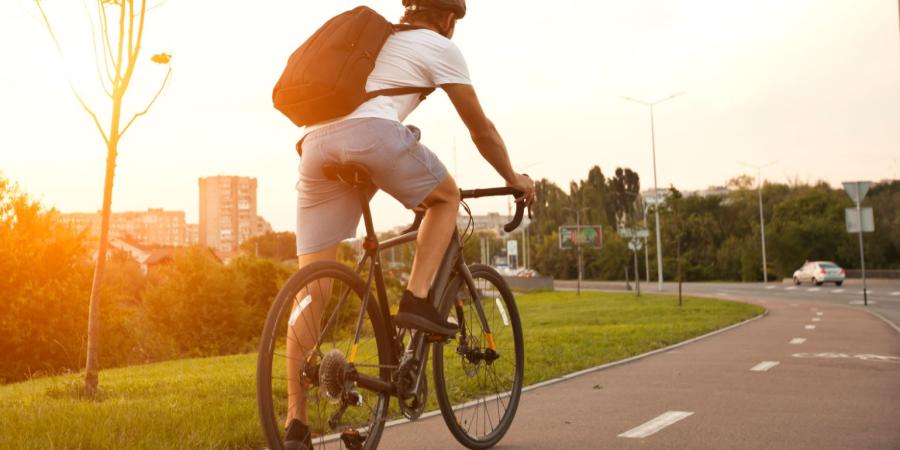 Biker der dem Sonnenuntergang entgegen radelt