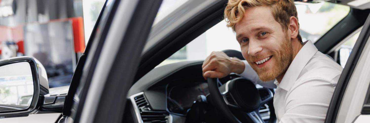 Gewerbeleasing bei Arval Mann mit weißem Hemd sitzt im Auto lächelnd
