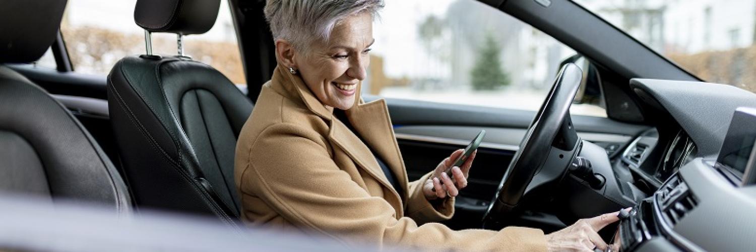 Seitliche Zoomaufnahme von Frau am Lenkrad in einem Car Sharing Auto von Arval
