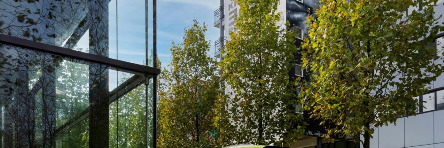 Auto umgeben von grünen Bäumen und modernen Hochhäusern - Fotoquelle: Arval