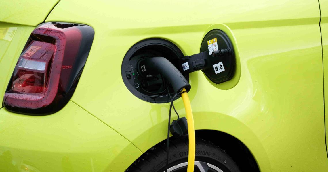 Arval Mittelstand-Ladevorgang am Elektroauto Zoomaufnahme eines gelben Elektroautos beim Ladevorgang