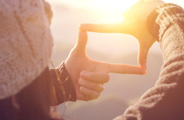 Frau zeigt mit Händen ein Rechteck als Symbol - Finden Sie Antworten auf häufig gestellte Fragen zur Vertragslaufzeit und rund um Ihr Auto von Arval