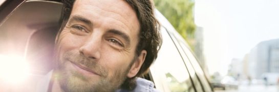 Mann schaut glücklich aus Autofenster - Erfahren Sie alles wichtige, dass Sie zum Leasing bei Arval wissen müssen.